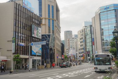 Downtown Kobe city street with bus and bustling pedestrians as well as businesses and commercial buildings in Kobe City, Hyogo, Japan