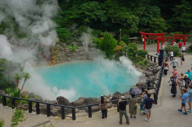 Japonya 'nın Beppu kentinden 21 Haziran 2025' te buhar yükselirken, Beppu Cehennemi 'ndeki ana Umi Jigoku kaplıcalarının etrafını turist kalabalığı sardı.