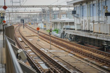 Yolcu platformunun yanındaki boş demiryolu hatları Hiroşima, Japonya 'da elektrik kablolarıyla çevrili.