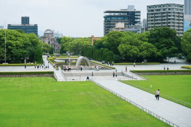 Hiroşima Barış Anıt Müzesi 'nden görüldüğü üzere, yayalar ve turistlerle dolu Barış Anıt Parkı, Hiroşima, Japonya' da Atom Bombası Kubbesi ile birlikte 12 Haziran 2025