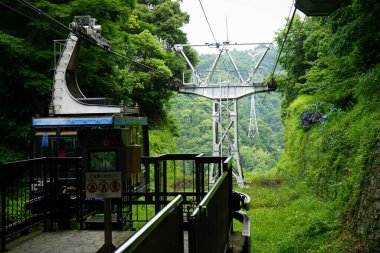 Nihondaira Ropeway 'deki teleferik, dağları aştıktan sonra Kunozan Toshogu Tapınağı platformuna ve Japonya' nın Shizuoka bölgesindeki bir ormana yaklaşır.