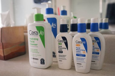 Çeşitli Cerave cilt bakımı ürünleri. Banyo tezgahında yüz nemlendirici, güneş kremi ve temizleyici de dahil.