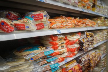 Uluslararası gıda reyonundaki raflarda bulunan un ve mısır tortillalarının yakın görüntüsü Albuquerque, NM, ABD 'deki Smith' in marketinin içinde.