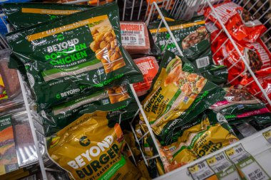 Bir bakkal dükkanının dondurucu bölümünde Beyond Burgers ve Beyond bitkisel tabanlı tavuk paketlerine yakından bakın.