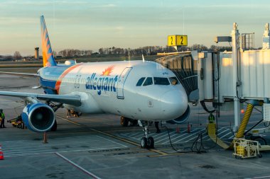 Knoxville 'in dışındaki McGhee Tyson Havalimanı' nda bağlı bir jet köprüsü olan Allegiant uçağının yakın görüntüsü. Gün batımında Alcoa, Tennessee, ABD