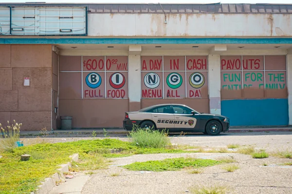 Albuquerque, New Mexico, ABD 'deki 66 numaralı otoyol boyunca Juan Tabo ve Central caddesindeki Franklin Plaza alışveriş merkezindeki terk edilmiş Route 66 Bingo binasının önüne park etmiş güvenlik aracı.