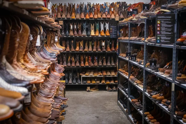 Las Cruces, New Mexico, ABD 'deki Boot Barn' ın batı giyim mağazasının raflarında sıra sıra kovboy çizmeleri olan koridor.