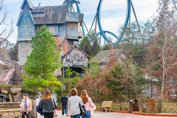 Turistler, ABD 'nin Tennessee kentindeki Pigeon Forge' da, arkasında Gizemli Maden hız treniyle Dollywood tema parkında bir patikada yürürler.