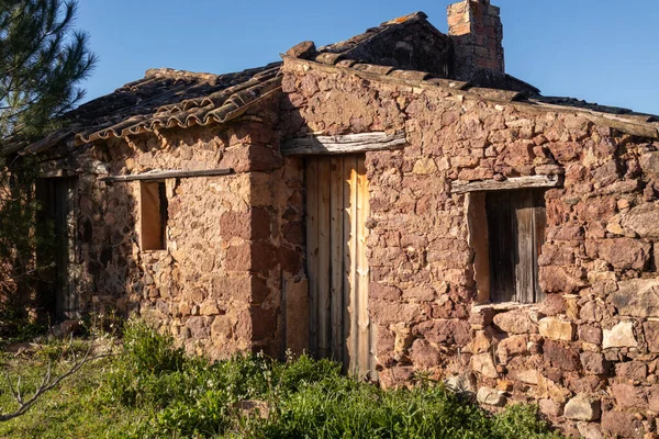 Provence kırsalında terk edilmiş taştan bir kulübe. Etrafı çimenler ve Akdeniz bitkileriyle çevrili..