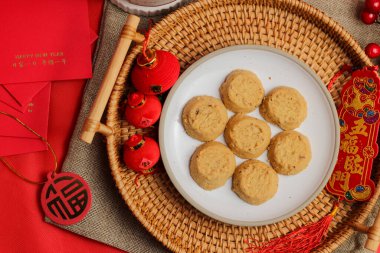 Tabakta altın yuvarlak şekilli vejetaryen badem kurabiyeleri Çin Yeni Yıl dekorasyonları ve sembolleri arasında servis ediliyor..