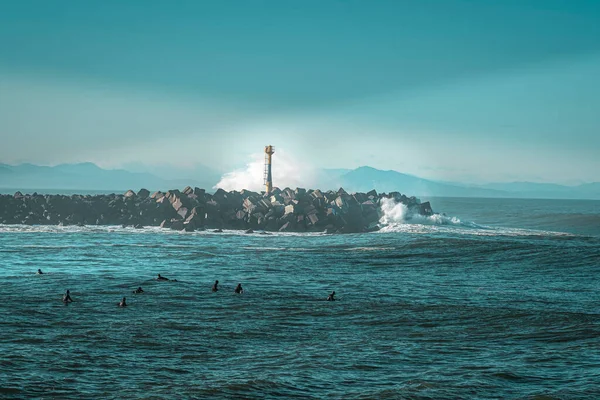 Fransa, Anglet, 2022-12-21. Anglet 'te bir sahilde sörfçülerin arkasında Pireneler var..