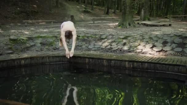 Un hombre está saltando en el lago del bosque, una vida muy feliz. Longitud completa vista de tamaño corporal — Vídeo de stock