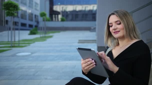 Hermosa joven usando tableta en la ciudad. Señora de negocios sostiene dispositivos pc. — Vídeo de stock