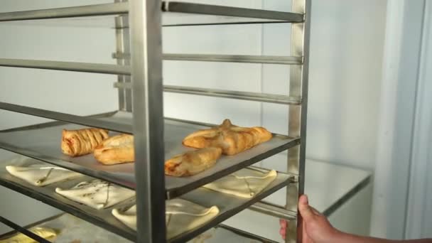 Horno de llenado Baker en panadería, panadería. El hombre mueve la bandeja con panes frescos — Vídeos de Stock