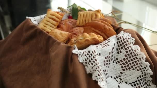 La mano de las mujeres deja un pastel. Pan fresco, bollos y galletas. Surtido de productos — Vídeo de stock