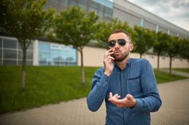 Saldırgan işadamı cep telefonuyla konuşurken akıllı telefona bağırıyor.