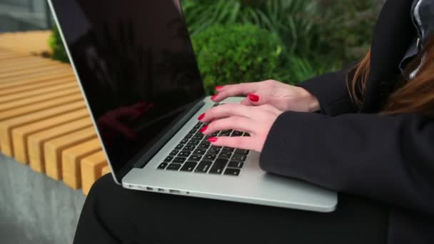 Primer plano de mecanografiar manos femeninas. Mujer dedos trabaja en el teclado portátil fuera — Vídeos de Stock