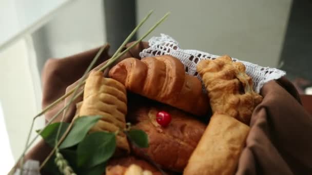 Bolinhos caseiros e pães em cesta de pão sobre fundo castanho. Estilo de vida — Vídeo de Stock