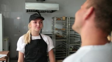 Genç adam dükkandan ekmek satın alır. Süpermarkete gidiyorum. Gülümseyen dost fırın