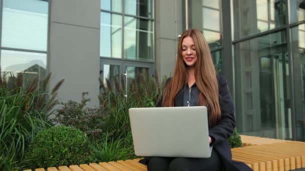 Wachten op partner. Portret van een mooie zakenvrouw in pak met laptop — Stockvideo