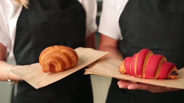 Retrato de dos guapas jóvenes y sonrientes panaderos masculinos posando, croissants — Vídeos de Stock