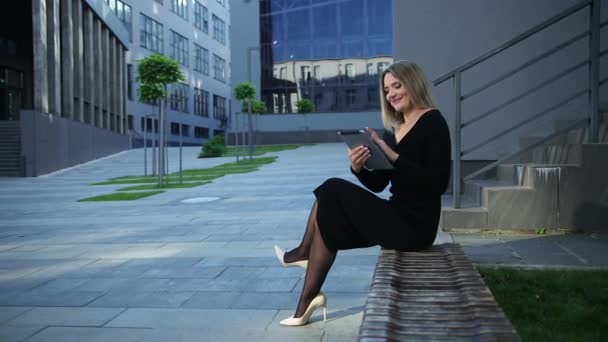 Schöne junge Frau mit Tablette in der Stadt. Geschäftsfrau hält digitalen PC in der Hand — Stockvideo