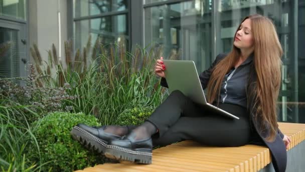Kvinnliga fötter på träbänk med laptop. Frilans, distansarbete utomhus. — Stockvideo