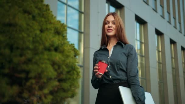 若いビジネスマンの女性がコーヒーノートパソコンを手に飲んでいる。美しい女性のオフィス — ストック動画