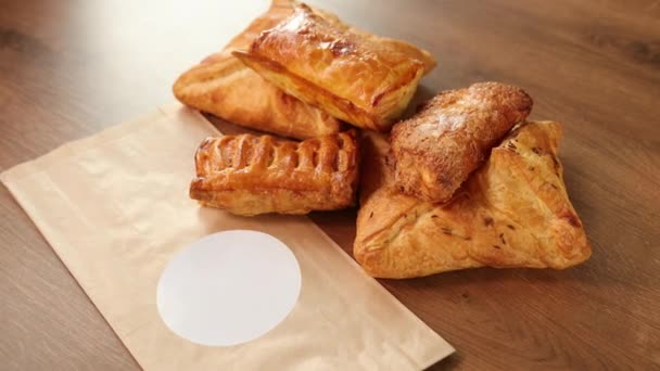 Delicious pastries on wooden table. Puff pastry with chocolate filling brown — Stock Video