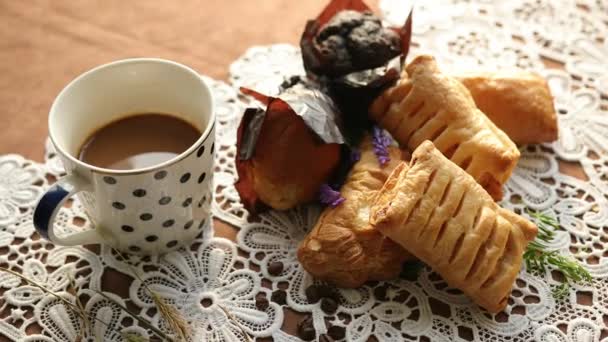 Galletas, pasteles y taza de café sobre mantel. Cruasán pastelero, cufalfo blanco — Vídeos de Stock