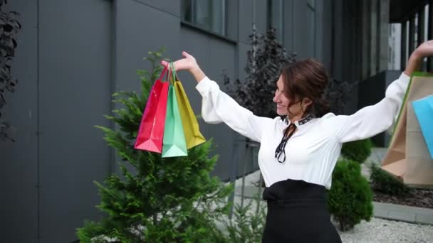 Elegantní elegantní dáma s barevnými tašky nákupní centrum pozadí. Balíčky — Stock video