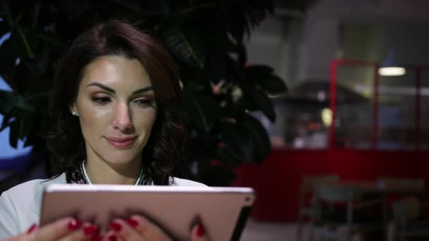 Genç ve güzel bir kadın kafedeki tablette video bağlantısıyla konuşuyor.. — Stok video
