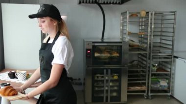 Kahve dükkanında kruvasan ve kapuçino satan bir satıcı. Genç kadın pastanesi