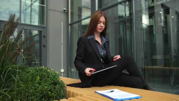 Femme d'affaires assise sur le banc. Jeune femme travaillant avec tablette pc — Video