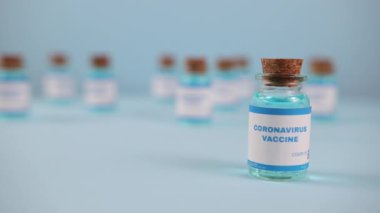 Şırınga iğnesi, bir damla sıvı, mavi arka planda bulanık pfizer şirketi..