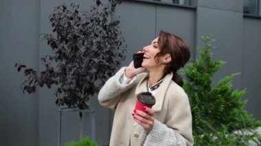 Genç bayan cep telefonuyla mutlu bir gülümsemeyle konuşuyor. İş molası. İş dünyası