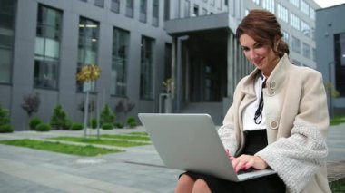 Diz üstü bilgisayarı dışarıda merdivenlerde oturan güzel bir iş kadını. Bayan bilgisayar.