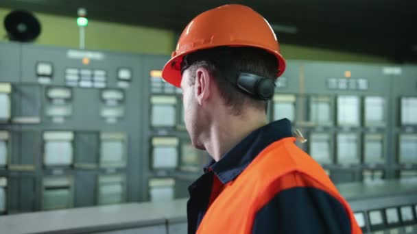 Ingénieur portant un masque de protection orange vérifier les tuyaux de température dans le contrôle — Video