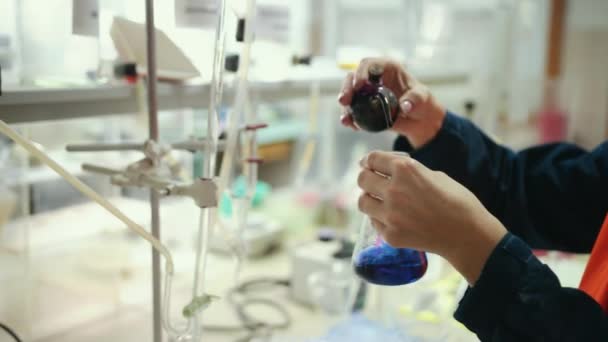 닫아. 매력적 인 젊은 여성 과학자가 액체 물질을 연구하다 — 비디오