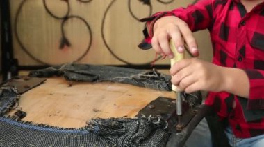 Çocuk sandalyeyi tornavidayla tamir ediyor vidaları söküyor, vidayı sıkıyor, cıvata takıyor. Efendim!