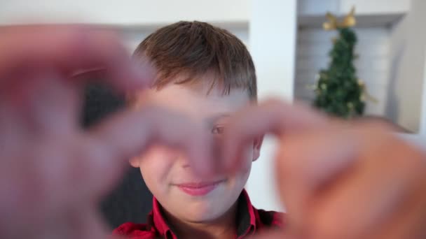 一个快乐的男孩的画像，他的心形是手工做的。小伙子表现出心形 — 图库视频影像