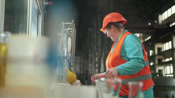 Mogen kvinna som arbetar i kemisk fabrik, fokuserad kvinnlig arbetare bär hatt — Stockvideo