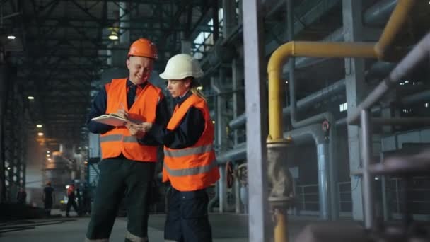 Gravação de informações na área de transferência. Tiro de dois trabalhadores alegres em hardhat — Vídeo de Stock