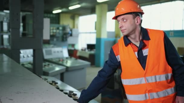 Ingeniero con una máscara protectora naranja, el dedo de la mano presiona el botón de control — Vídeo de stock