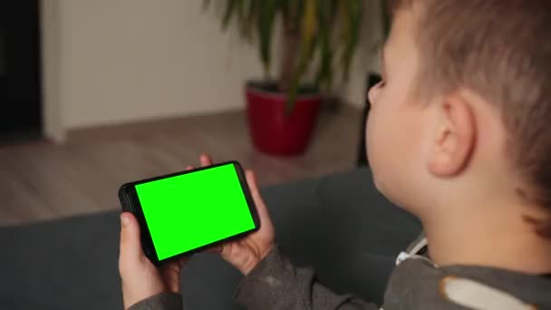 Barn med digital innretning. Mobil søknad for et barn. Boy bruker mobiltelefon. – stockvideo