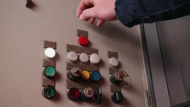 Ingenjör står framför industrimaskin och kommer att trycka på en knappar — Stockvideo
