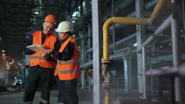 İki bakım mühendisi, erkek, kadın denetleyici. Ağır sanayi imalatı