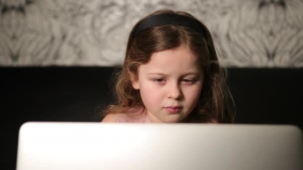 Retrato de chica joven sosteniendo portátil. La muchacha usa la computadora en casa. Seis años 6 — Vídeo de stock