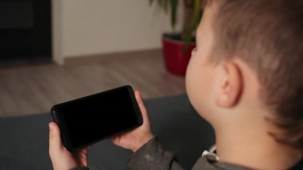 Jovem rapaz usando vídeo chat no smartphone em casa, close-up. Espaço para design. — Vídeo de Stock