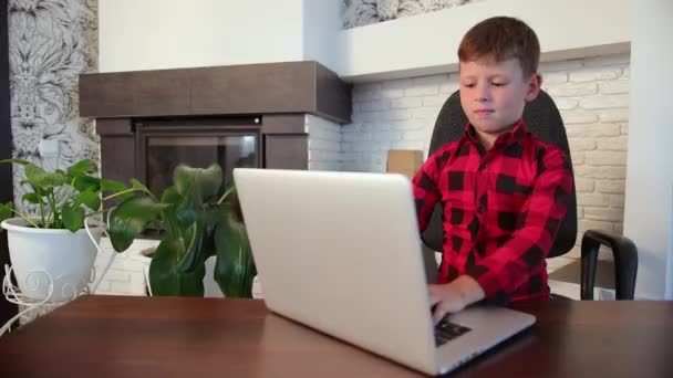 Joven chico caucásico jugando juegos de ordenador en serio. Lindo muchacho estudiando. — Vídeos de Stock